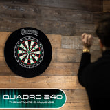 Harrows Quadro 240 Dartboard lifestyle image showing the dartboard installed and ready for play in a real world setting with a player using the dartboard